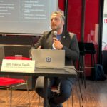 Relatore che interagisce con un partecipante durante la sessione di Q&A sull’applicazione della NIS2.